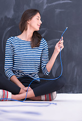 Image showing woman holding a internet cable in front of chalk drawing board