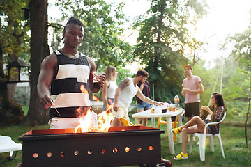 Image showing Group of friends making barbecue in the backyard. concept about good and positive mood with friends