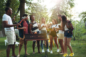 Image showing Group of friends making barbecue in the backyard. concept about good and positive mood with friends