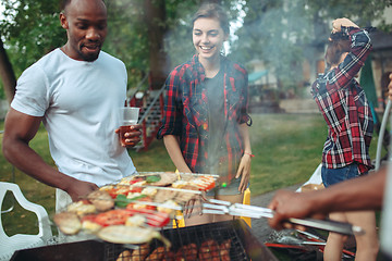 Image showing Group of friends making barbecue in the backyard. concept about good and positive mood with friends