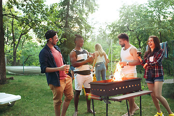 Image showing Group of friends making barbecue in the backyard. concept about good and positive mood with friends