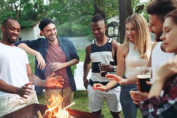 Image showing Group of friends making barbecue in the backyard. concept about good and positive mood with friends