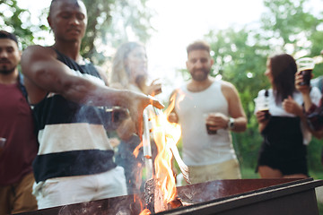 Image showing Group of friends making barbecue in the backyard. concept about good and positive mood with friends