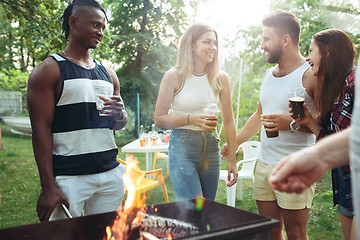 Image showing Group of friends making barbecue in the backyard. concept about good and positive mood with friends