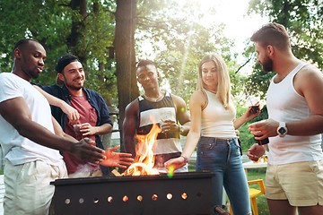 Image showing Group of friends making barbecue in the backyard. concept about good and positive mood with friends