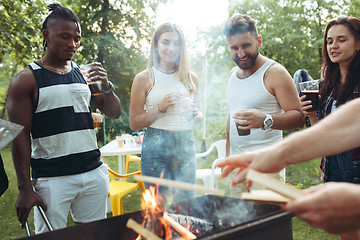 Image showing Group of friends making barbecue in the backyard. concept about good and positive mood with friends