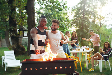 Image showing Group of friends making barbecue in the backyard. concept about good and positive mood with friends