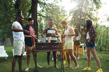 Image showing Group of friends making barbecue in the backyard. concept about good and positive mood with friends