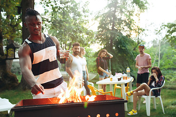 Image showing Group of friends making barbecue in the backyard. concept about good and positive mood with friends