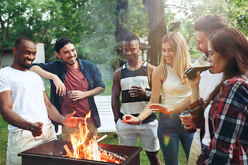 Image showing Group of friends making barbecue in the backyard. concept about good and positive mood with friends