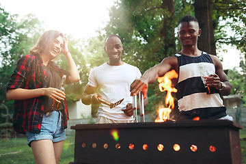 Image showing Group of friends making barbecue in the backyard. concept about good and positive mood with friends