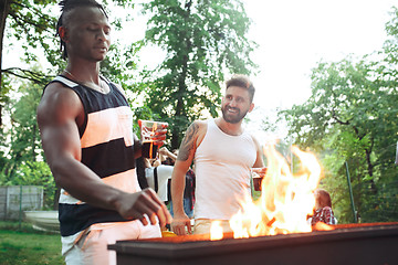 Image showing Group of friends making barbecue in the backyard. concept about good and positive mood with friends