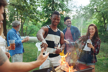 Image showing Group of friends making barbecue in the backyard. concept about good and positive mood with friends