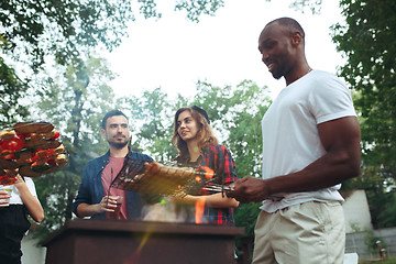 Image showing Group of friends making barbecue in the backyard. concept about good and positive mood with friends