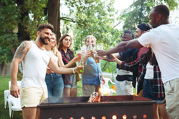 Image showing Group of friends making barbecue in the backyard. concept about good and positive mood with friends