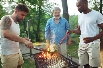 Image showing Group of friends making barbecue in the backyard. concept about good and positive mood with friends