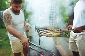 Image showing Group of friends making barbecue in the backyard. concept about good and positive mood with friends