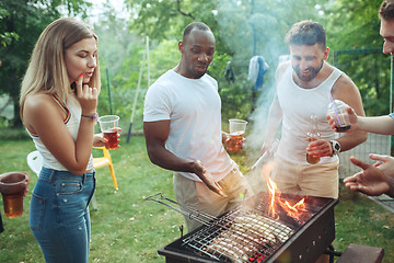 Image showing Group of friends making barbecue in the backyard. concept about good and positive mood with friends