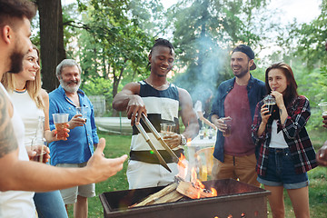 Image showing Group of friends making barbecue in the backyard. concept about good and positive mood with friends