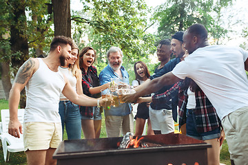 Image showing Group of friends making barbecue in the backyard. concept about good and positive mood with friends