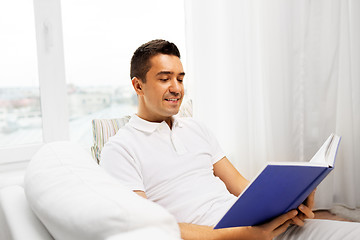 Image showing happy man reading book at home