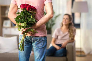 Image showing woman and man with bunch of roses behind his back