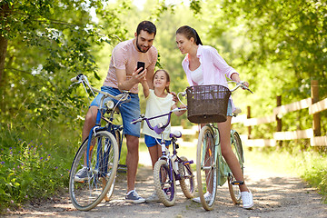 Image showing family with smartphone and bicycles in summer park