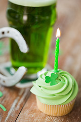 Image showing green cupcake with candle, beer and horseshoe