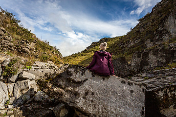 Image showing Woman sitting on rock with sea fossils more than 1200 mtrs above sea