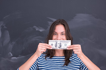 Image showing woman holding a banknote in front of chalk drawing board