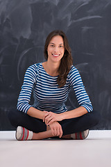 Image showing woman sitting in front of chalk drawing board