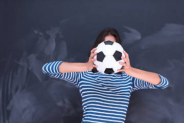 Image showing woman holding a soccer ball in front of chalk drawing board