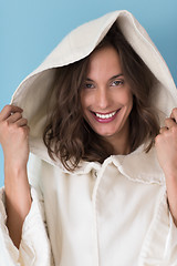 Image showing woman in a white coat with hood isolated on blue background