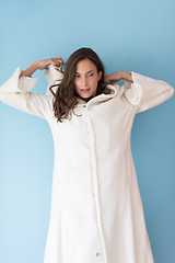 Image showing woman in a white coat with hood isolated on blue background