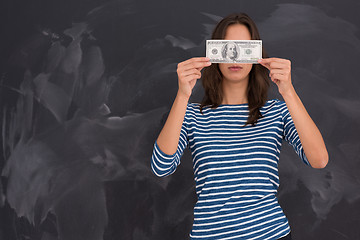 Image showing woman holding a banknote in front of chalk drawing board