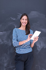 Image showing woman using tablet  in front of chalk drawing board