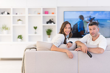 Image showing Young couple on the sofa watching television