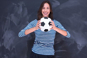 Image showing woman holding a soccer ball in front of chalk drawing board