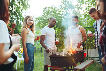 Image showing Group of friends making barbecue in the backyard. concept about good and positive mood with friends