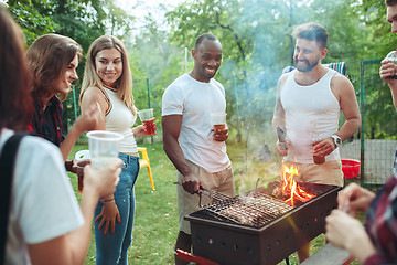 Image showing Group of friends making barbecue in the backyard. concept about good and positive mood with friends