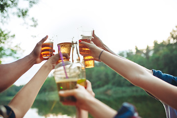 Image showing Bottles of beer in people\'s hands on blue sky background