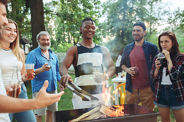 Image showing Group of friends making barbecue in the backyard. concept about good and positive mood with friends