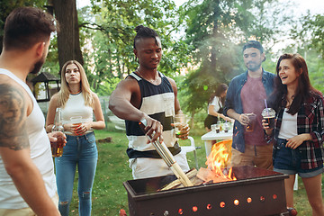 Image showing Group of friends making barbecue in the backyard. concept about good and positive mood with friends