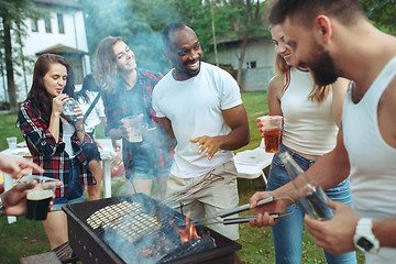 Image showing Group of friends making barbecue in the backyard. concept about good and positive mood with friends