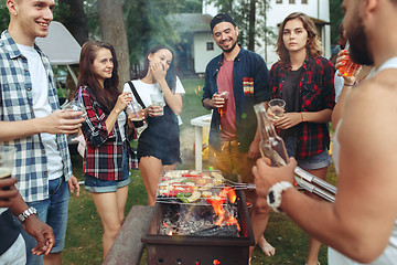 Image showing Group of friends making barbecue in the backyard. concept about good and positive mood with friends