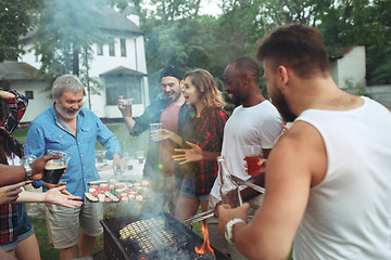 Image showing Group of friends making barbecue in the backyard. concept about good and positive mood with friends