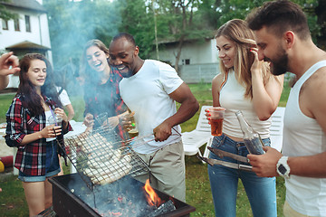 Image showing Group of friends making barbecue in the backyard. concept about good and positive mood with friends