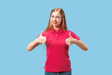 Image showing The happy business woman standing and smiling against blue background.