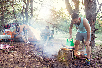 Image showing Party, camping of men and women group at forest. They relaxing, singing a song and cooking barbecue