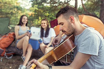 Image showing Party, camping of men and women group at forest. They relaxing, singing a song